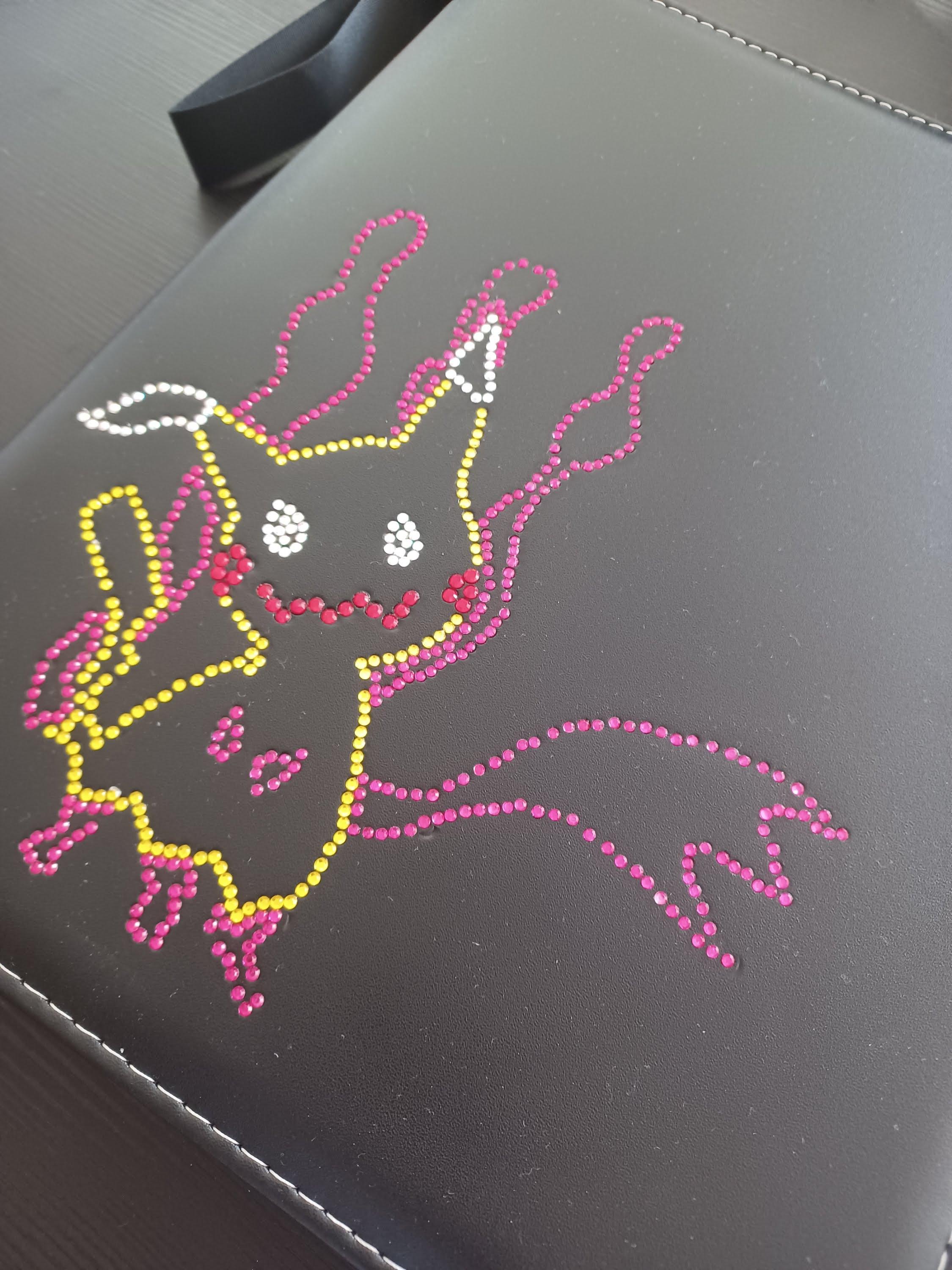 Angled picture of our Custom Binder decorated with a rhinestone mimikyu Design