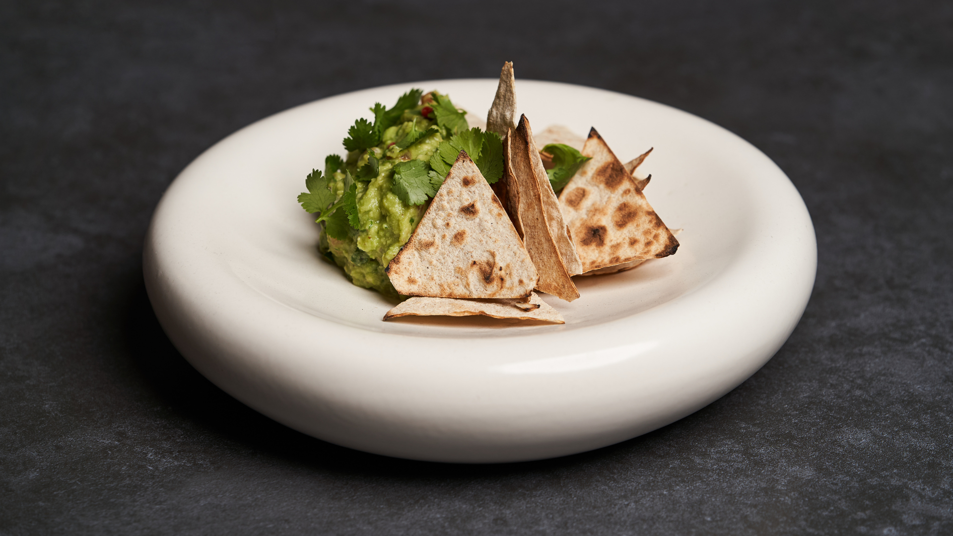 Plat gastronomique de guacamole et tortillas mis en valeur pour un catalogue de commande en ligne SumUp.