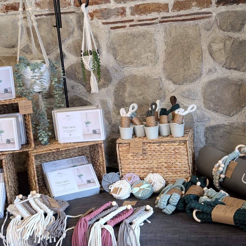 Flat lay of traditional macramé wall hanging in progress, featuring natural cotton cord, driftwood, wooden beads, and spools of twine.
Handmade fibre art setup by Forget Me Knots