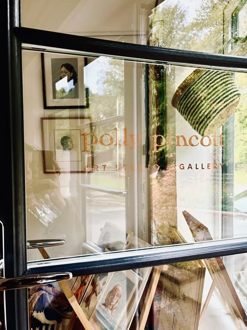 Picture through the window of Polly Pincott Art Studio Gallery, featuring some of the art inside the gallery