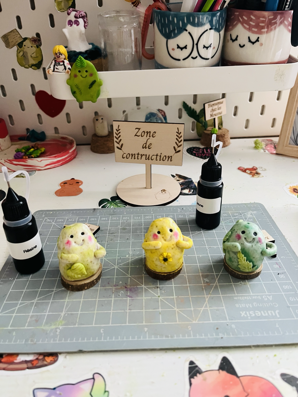Gardiens Moussus dans l’atelier devant la pancarte Zone de construction du village.