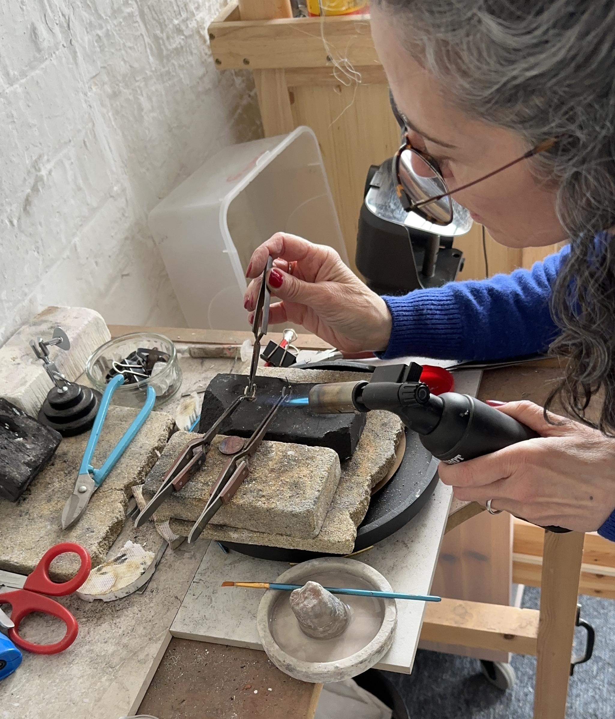 Angela making silver jewellery by hand at her jewellery bench
