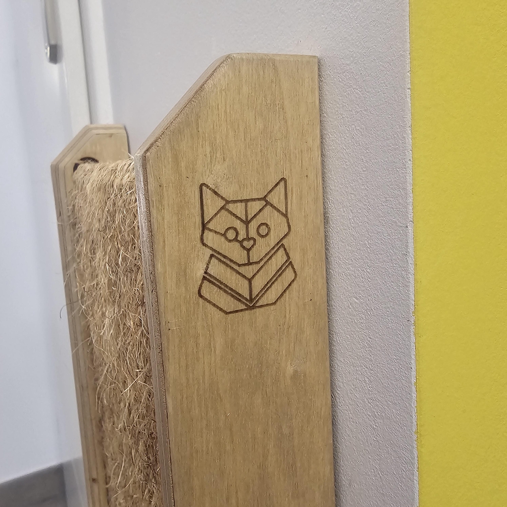 Griffoir mural d'angle pour chat en bois de peuplier artisanal et sisal naturel tressé, installé à côté d'une porte blanche dans un intérieur moderne, signé Chat Envoie du Bois.