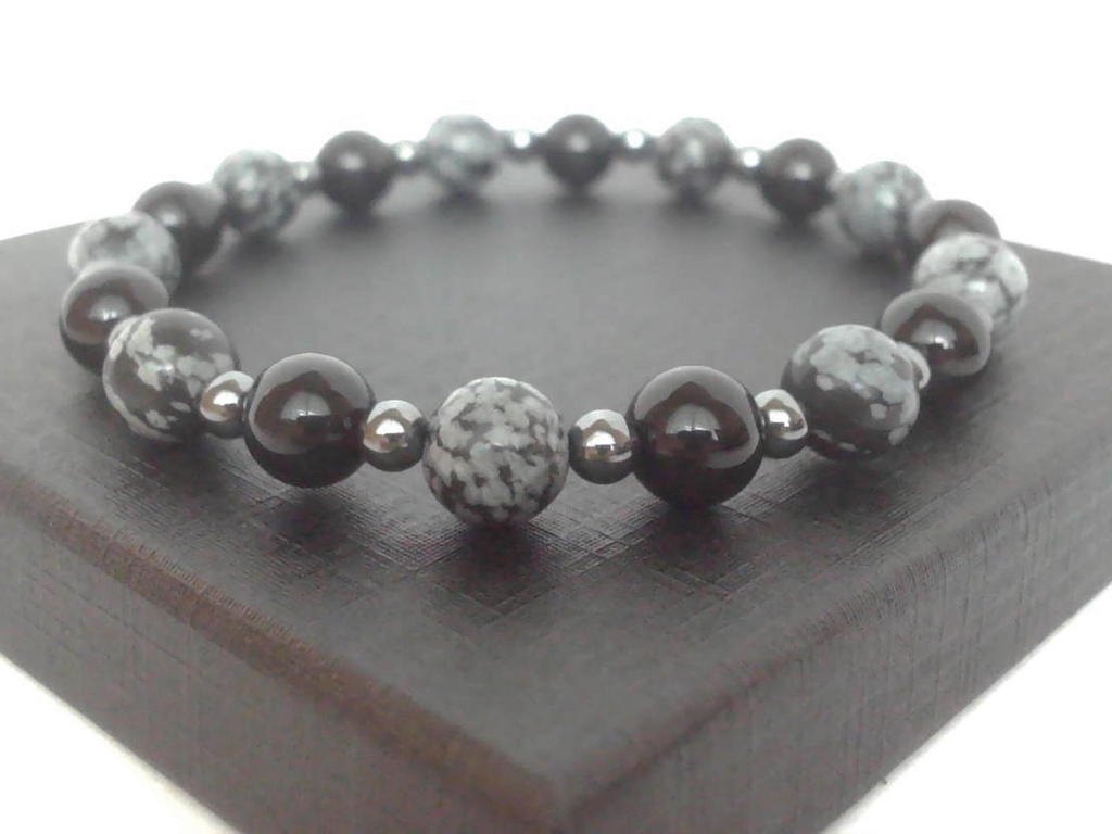 Beaded bracelet in grey and black tones, featuring mottled grey and black, glossy black and shiny grey beads.