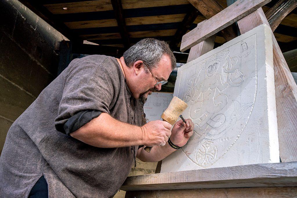 Christophe Chevènement tailleur de pierre en cours de travail sur une pierre