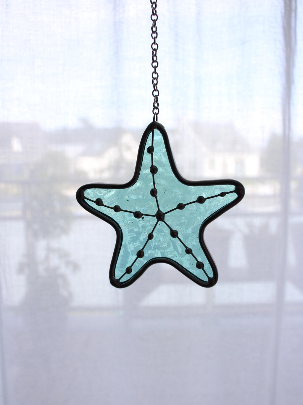 Photo de Atelier Vitraï montrant une étoile de mer verte en vitrail Tiffany.