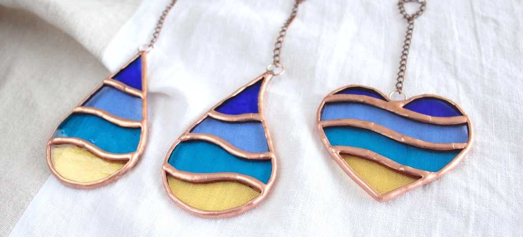 Photo de Atelier Vitraï montrant 3 suspensions multicolores en vitrail Tiffany, inspirées du bord de mer.