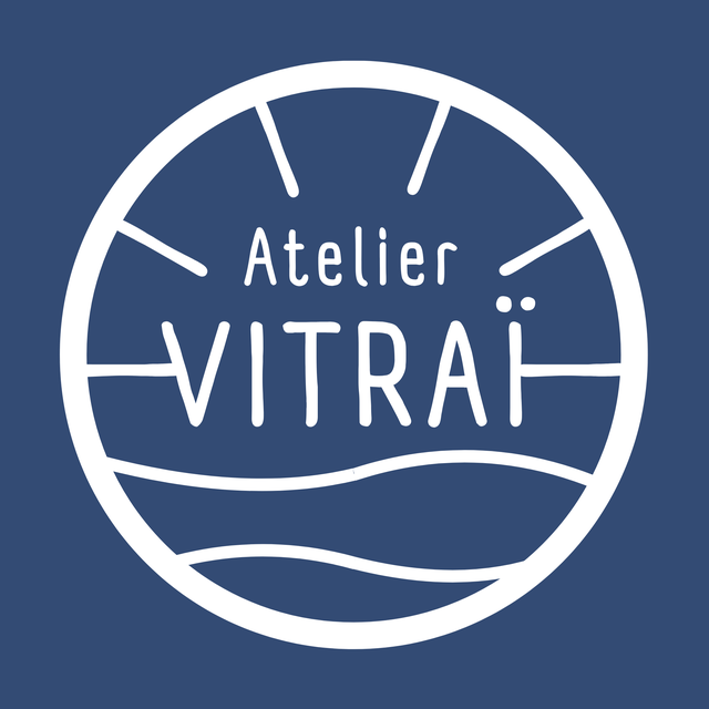 Logo de la marque Atelier Vitraï. Logo circulaire blanc sur un fond bleu.