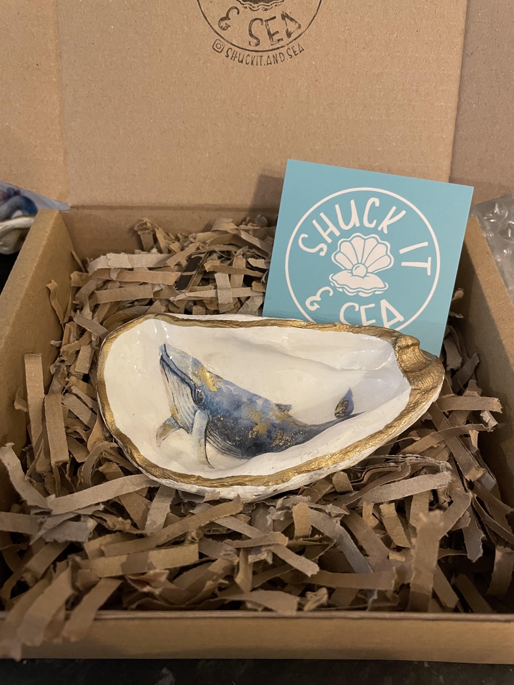 gift wrapped oyster shell, blue whale, pigmented shiny gold, sustainable packaging, eco friendly