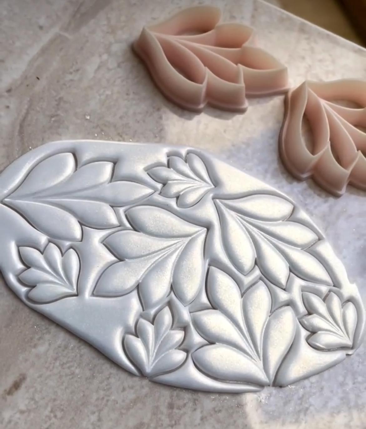 Handmade polymer clay earring shapes in progress, cut and ready for baking