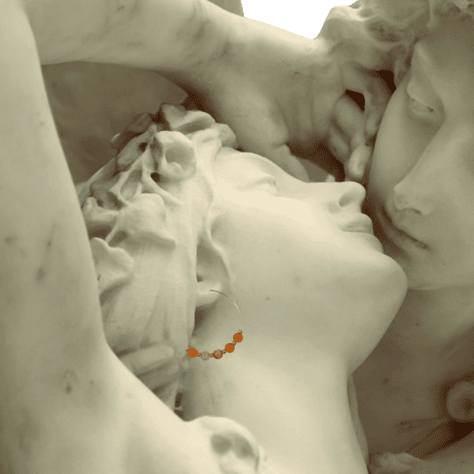 Sculpture de marbre portant des créoles de pierres naturelles oranges, en cornaline – bijoux fantaisie Les Althëis