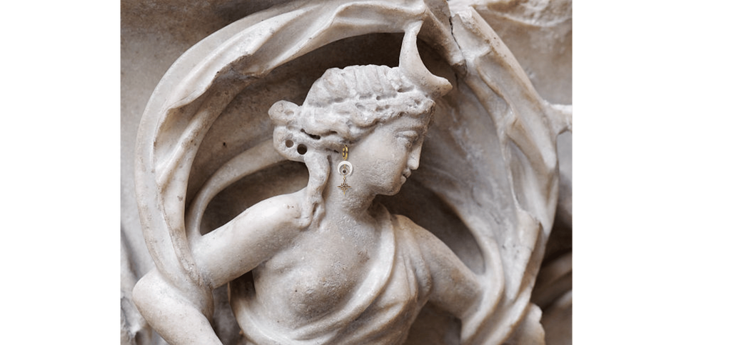 Créoles pendantes demi-lune en nacre Eclipse portées sur une statue grecque antique représentant Séléné. Bijoux mythologie grecque Les Althëis, fabriqués en France
