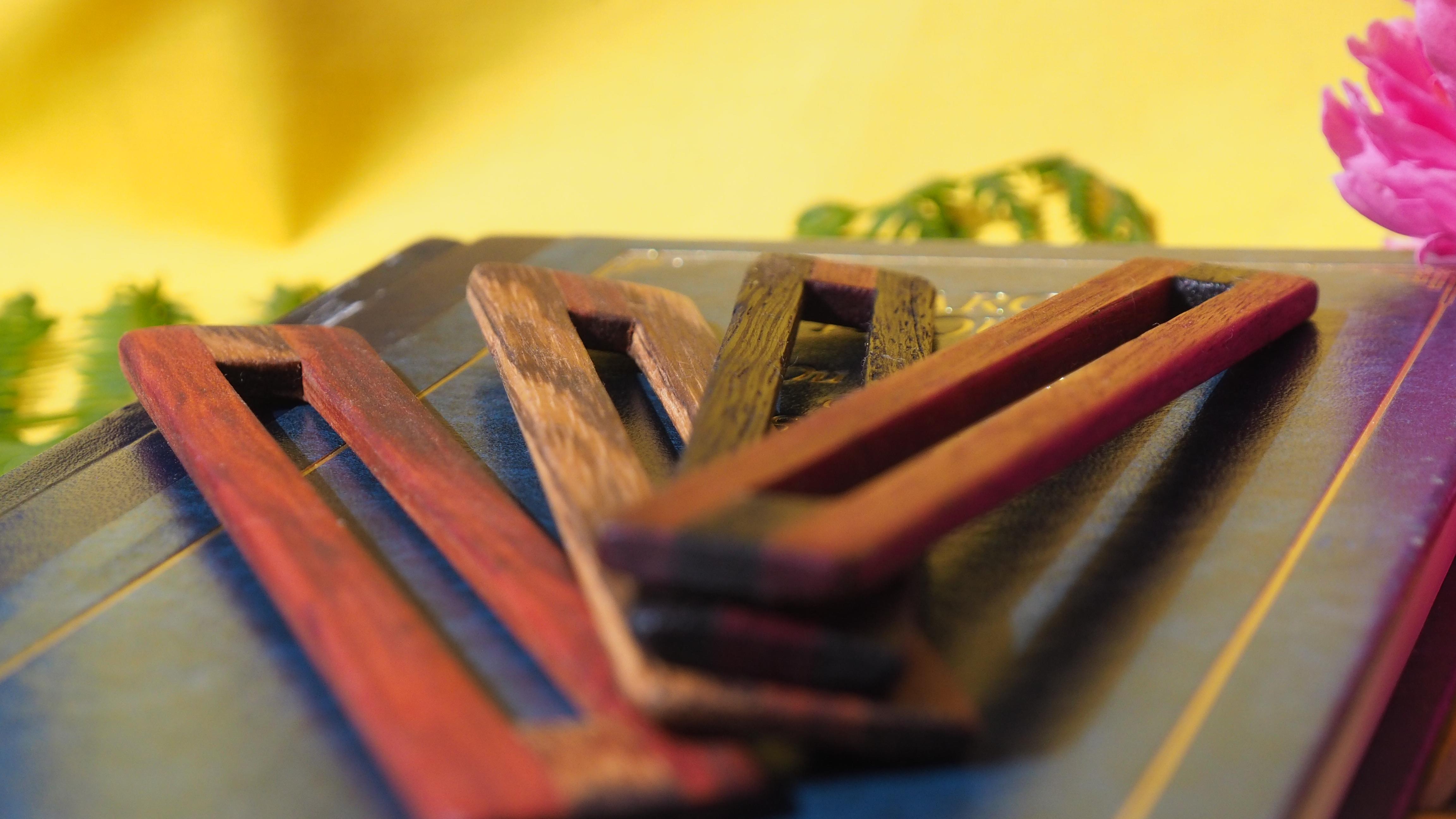 Photo de plusieurs règles de lecture. Ce sont des petites règles faites dans des bois colorés, avec une rainure au centre, ce qui permet d'isoler une ligne dans un texte pour rendre la lecture plus facile.