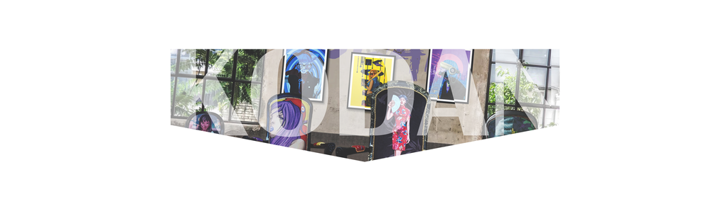 Bannière de l'artiste Kodan représentant une salle avec différents tableaux accrochés sur un mur et des chaises Voltaire customiser de ses peintures.