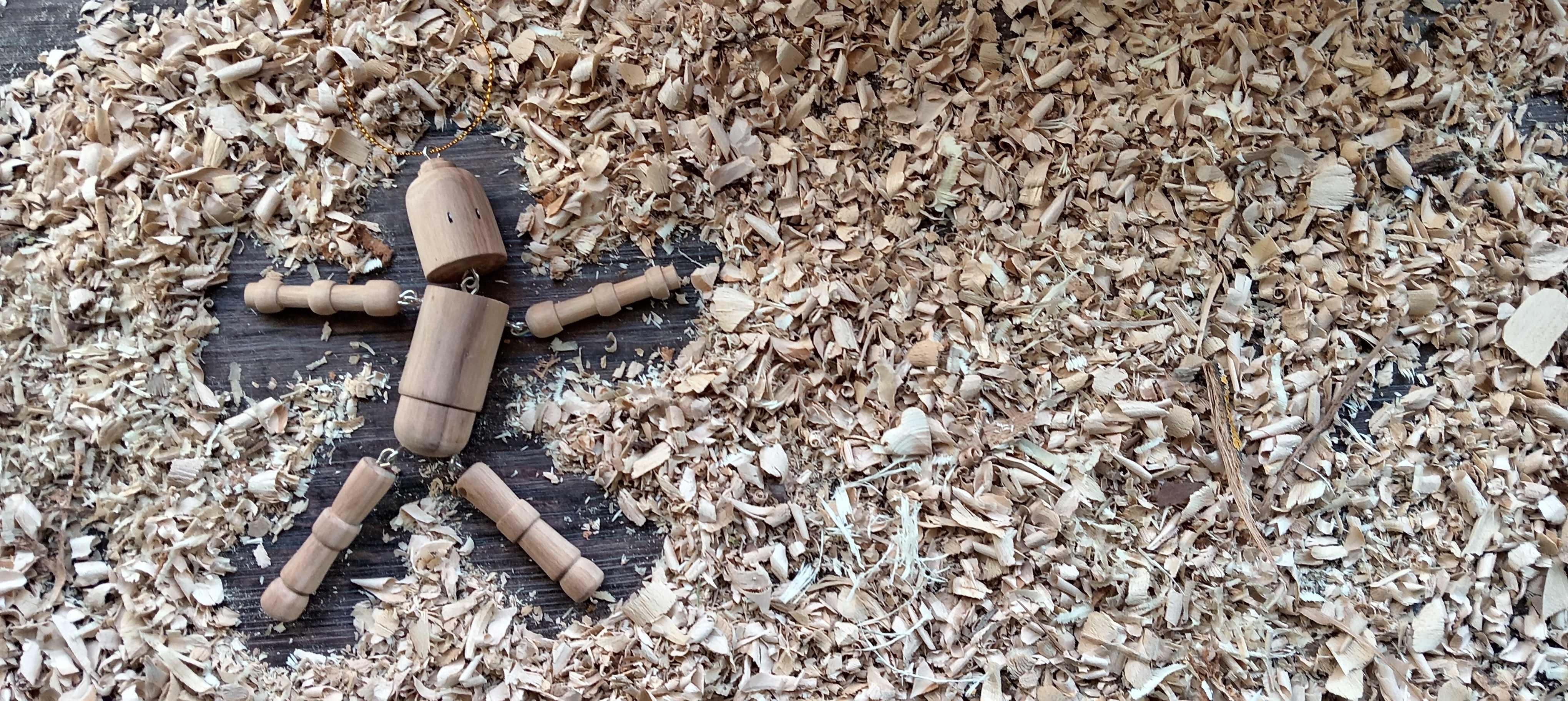 pantin en bois couché dans un lit de copeaux de bois