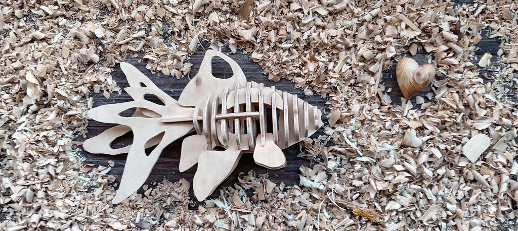 Poisson en bois posé dans un lit de copeaux