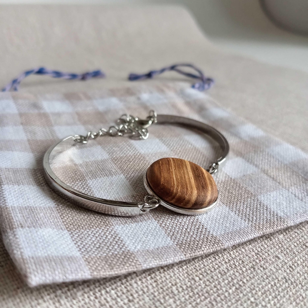 Bracelet en métal avec un insert en bois de frêne olivier sur tissu à carreaux