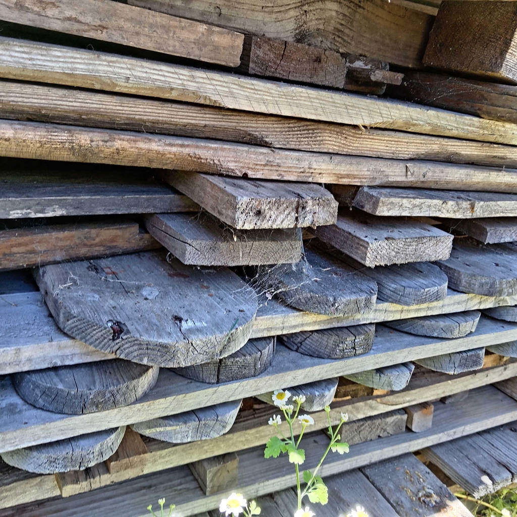 Planches de bois de palette empilées les unes sur les autres grisées par le soleil.