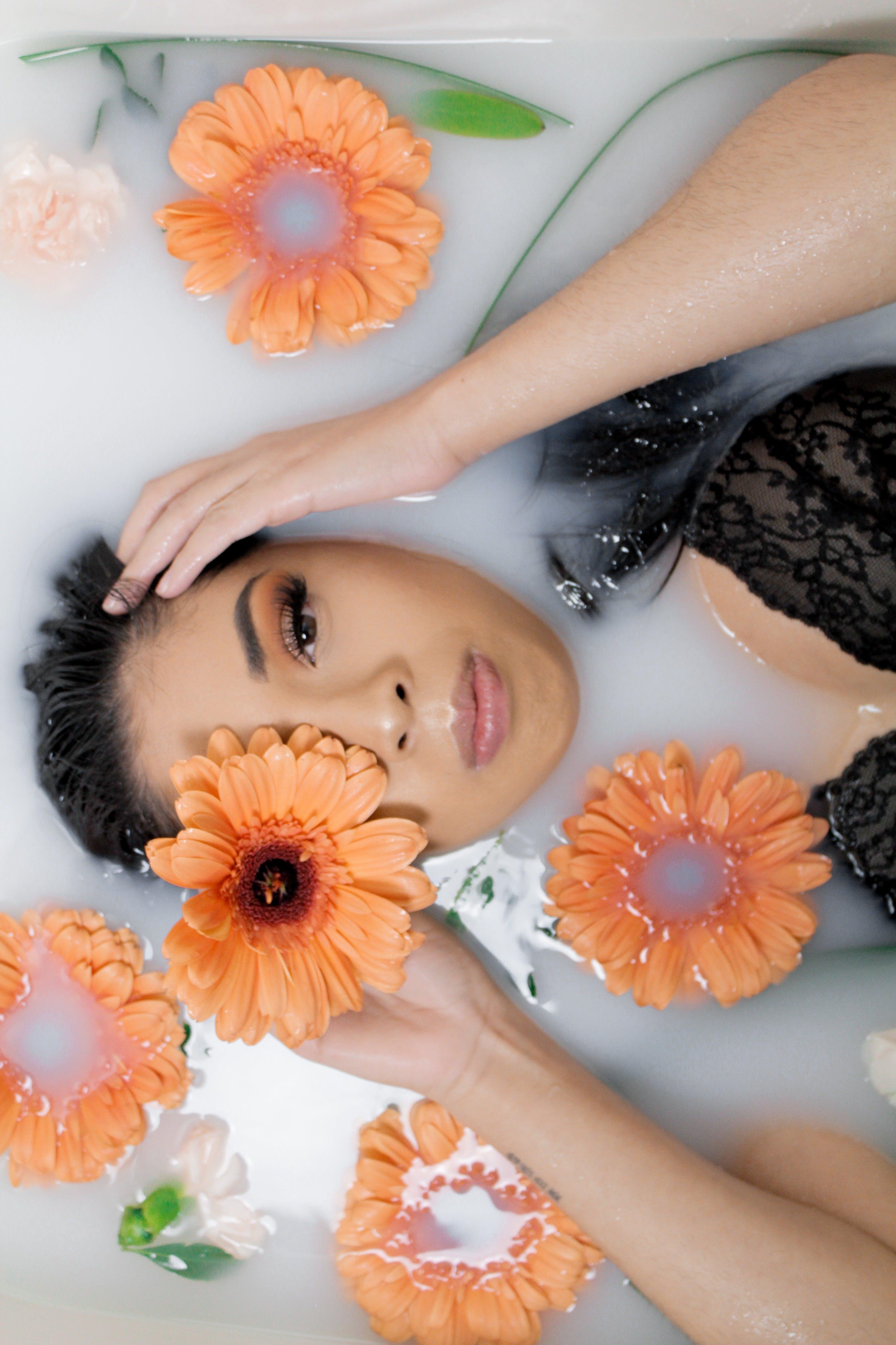 woman surrounded by flowers in a bathtub.