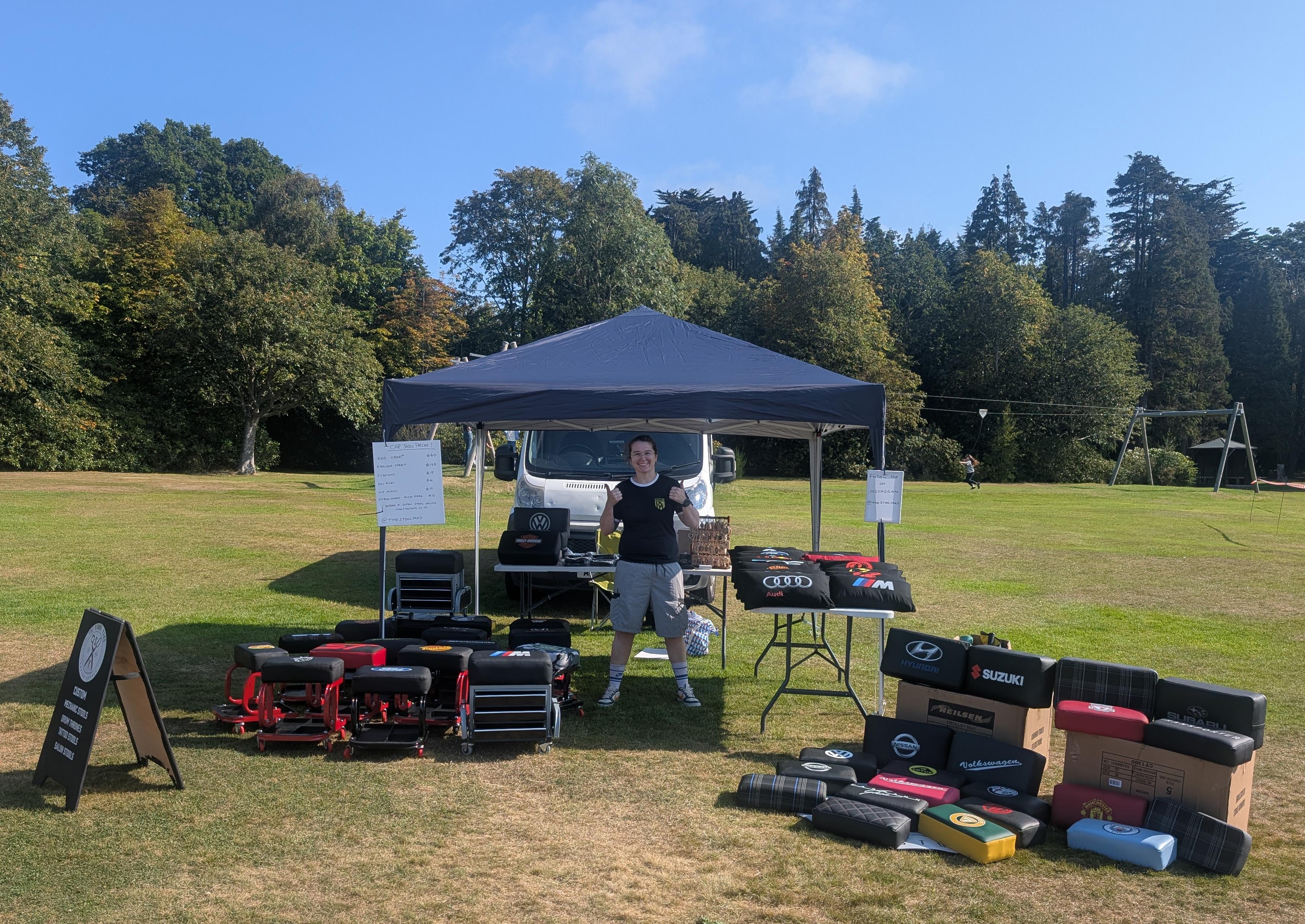 The Stool Yard founder at a car show, in the sun, surrounded by custom mechanics creepers and car accessories
