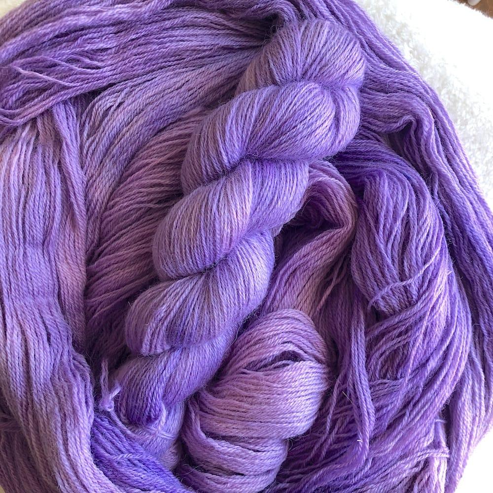 Plusieurs écheveaux de laine anglaise de chez John Arbon Textiles étalés sur une table, laine teinte à la main par Madame Guillotine