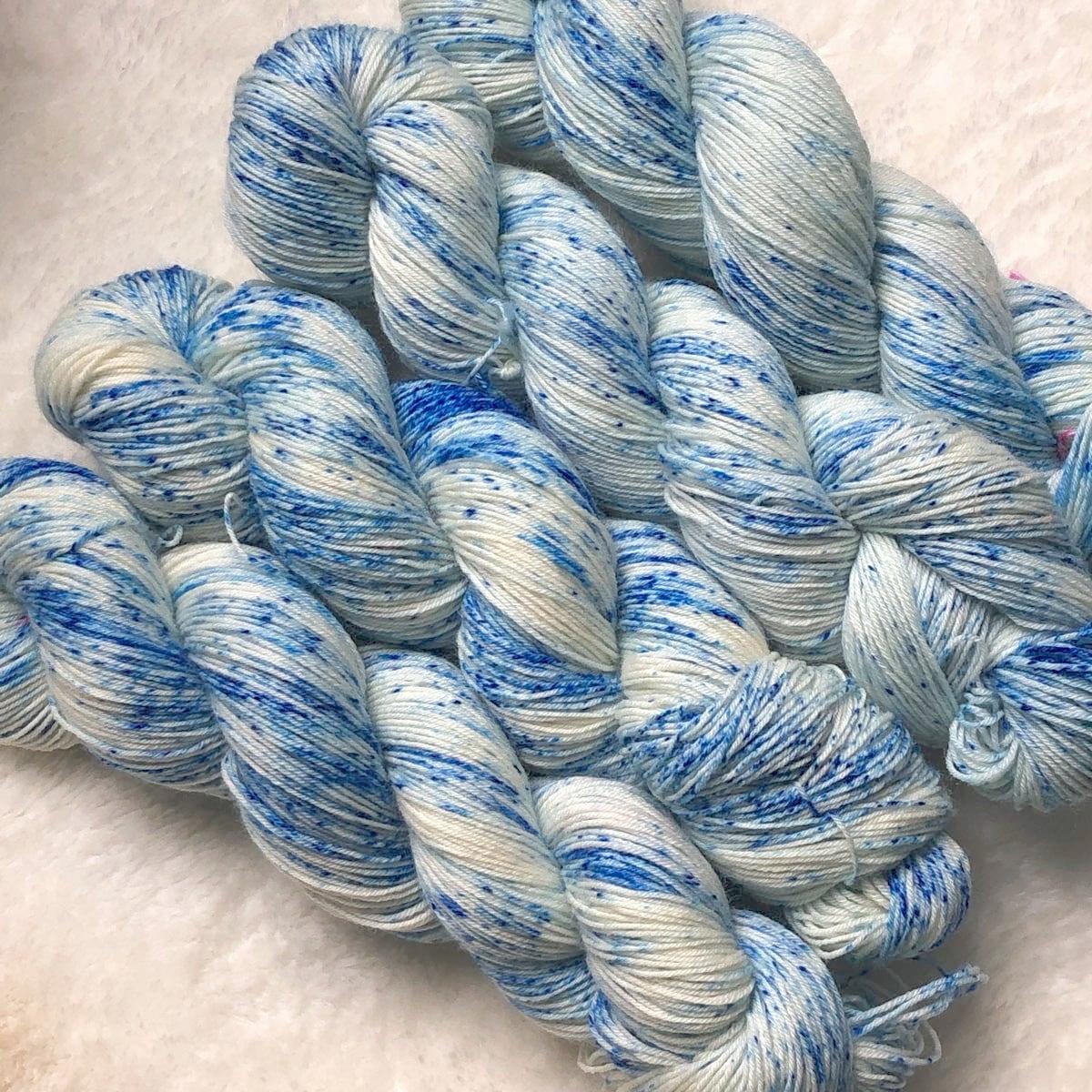 Quatre écheveaux de laine Bluefaced Leicester teints à la main par Madame Guillotine parsemés de speckles bleu