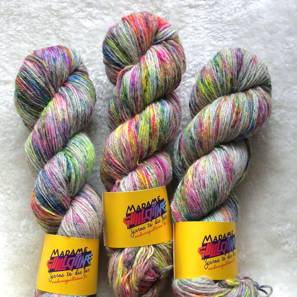 Trois écheveaux de laine teinte à la main par Madame Guillotine couverts de speckles fluo