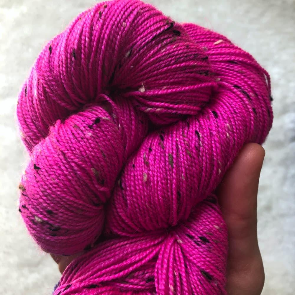 Un écheveau de laine teint à la main par Madame Guillotine dans un ton fuchsia fluo