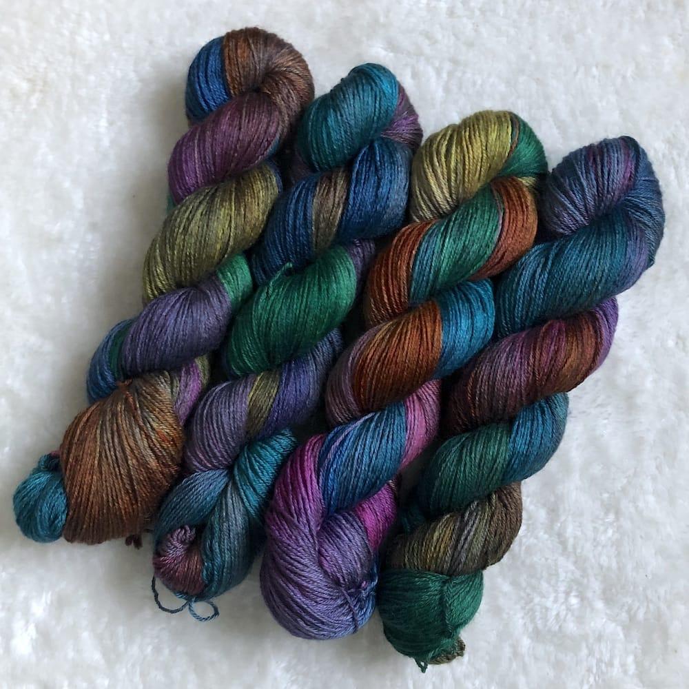 Quatre écheveaux de laine BFL et soie teinte à la main par Madame Guillotine en couleurs arc-en-ciel foncé