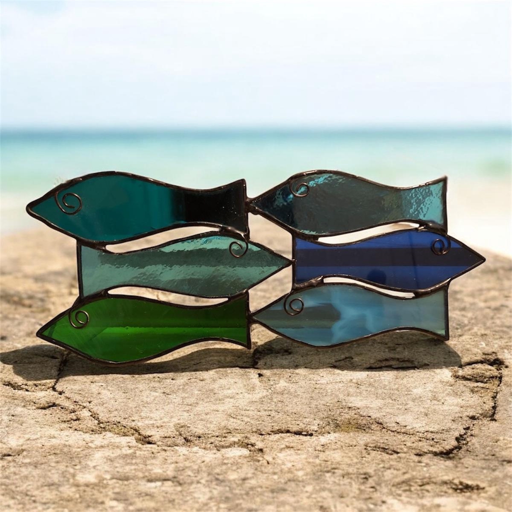 Stained glass fishes in blue, green and turquoise.