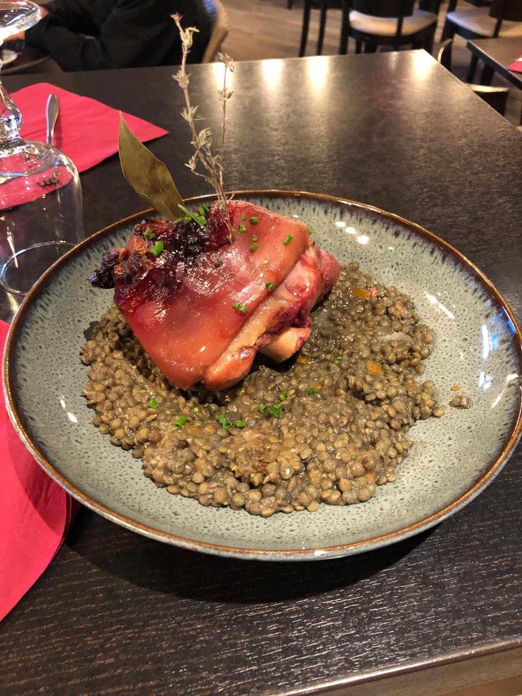 Plat de lentilles vertes cuisinées avec morceau de porc, servi à l’assiette