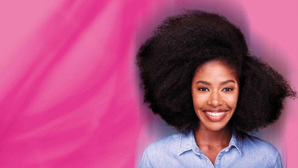 Femme avec des cheveux afro qui sourit