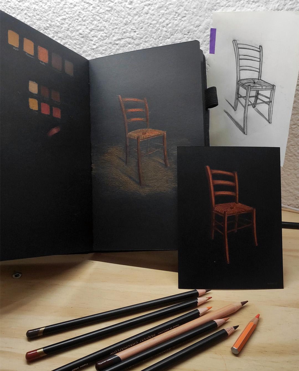 Photo du croquis et du dessin final de l'illustration d'une chaise aux crayons de couleur sur papier noir.