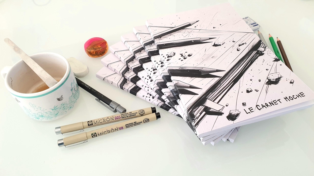 Carnets de dessin avec crayons et feutres, gomme, taille crayon, tasse de café