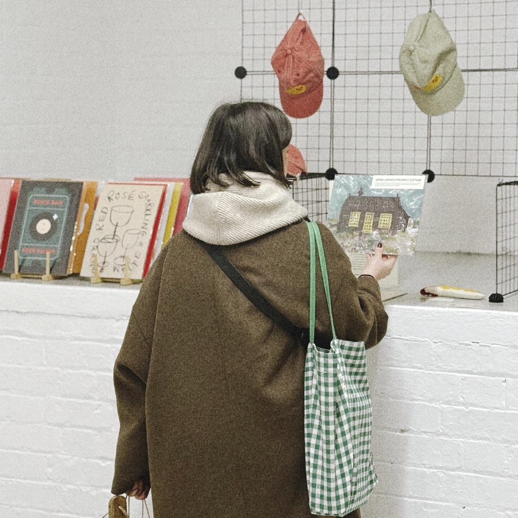 Lady holding up art print in studio 