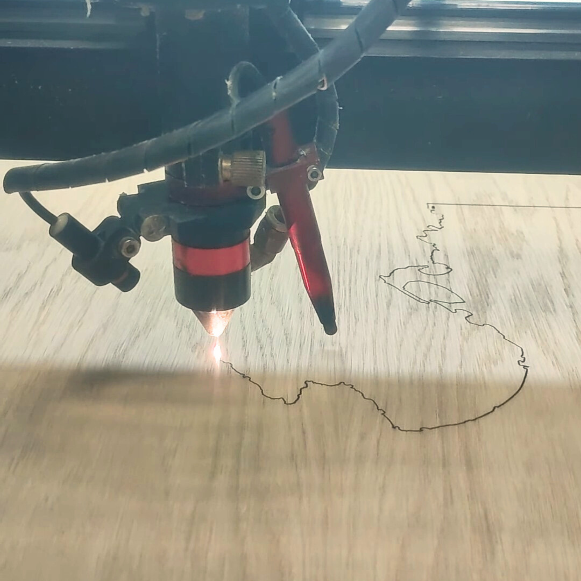 découpe laser du littoral sur une planche de bois