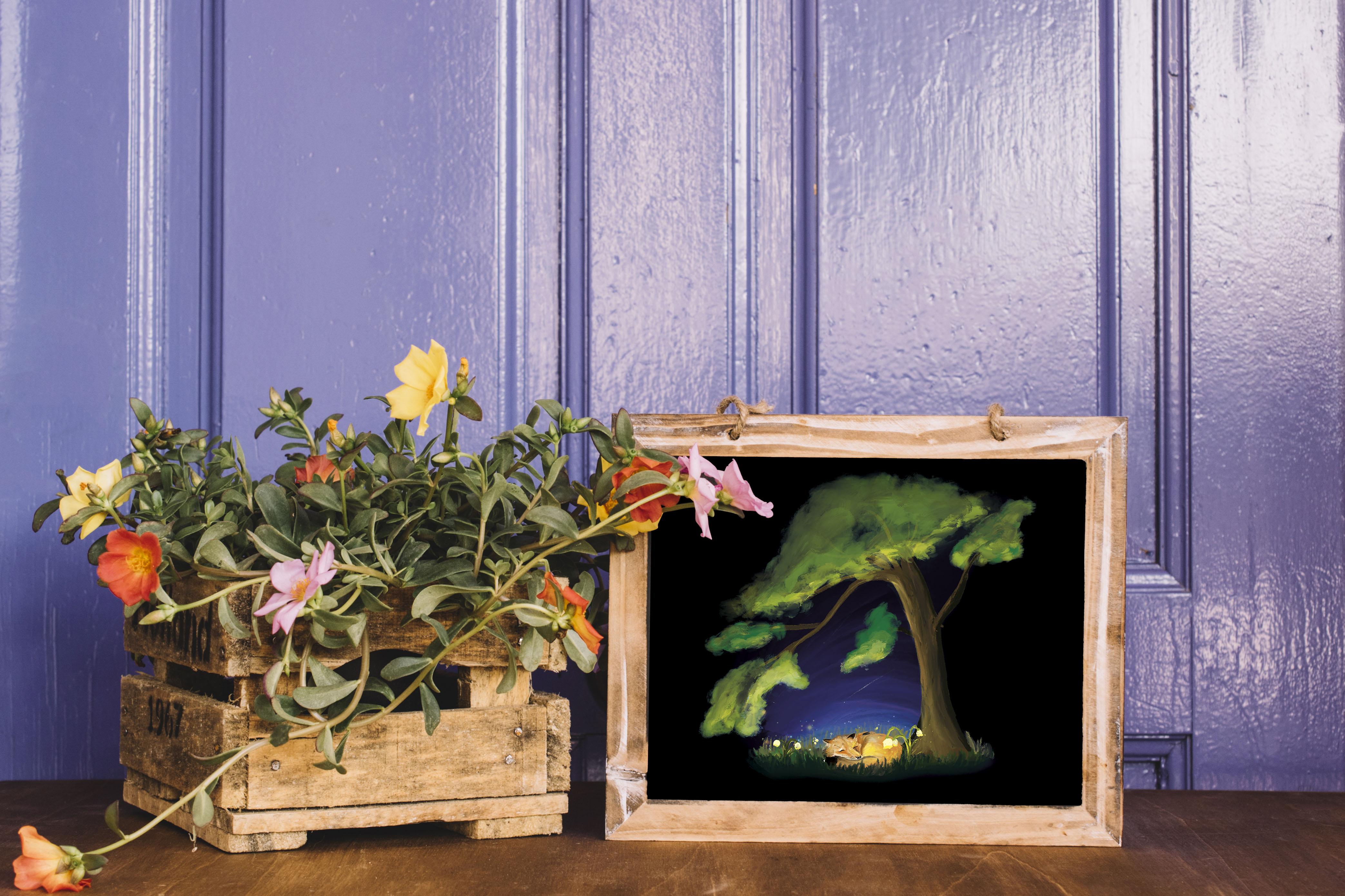 Tableau à coté de fleur. Illustration d'un renard dormant au pied d'un arbre qui l'encercle tel une couverture contre l’obscurité. Autour du renard une bulle de couleurs, laissant apparaitre la nuit bleuté et l’herbe vert mélanger de clochettes lumineuse, telle un rêve.