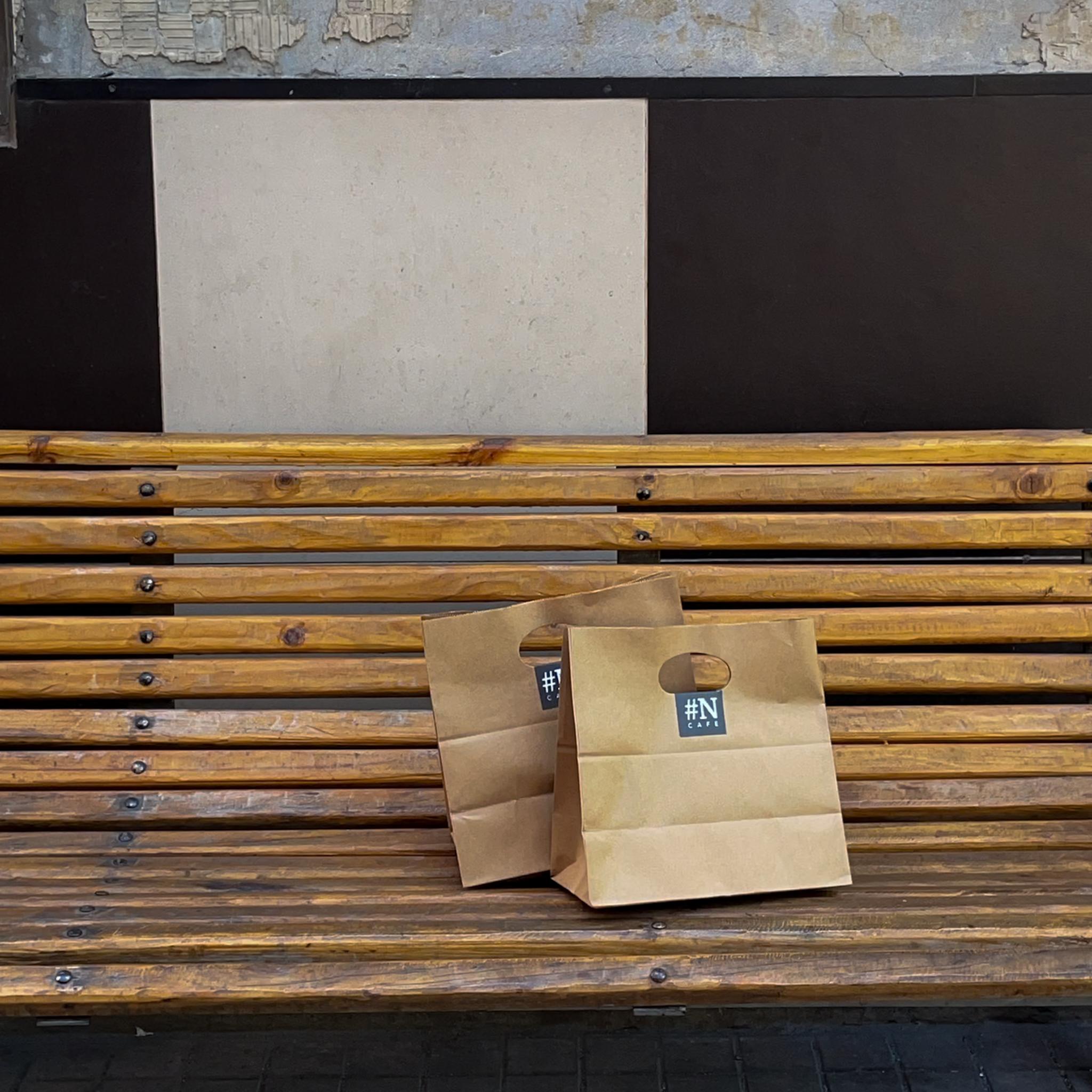 Bolsas de Numeral Café sobre una banca en la calle