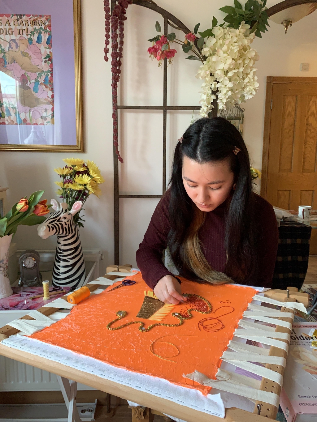 Girl doing hand embroidery on the frame. Behind the Scenes of Frangibella.
