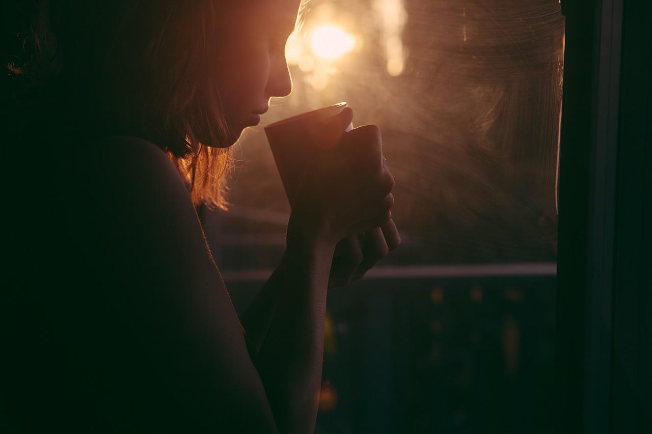 Tasse de thé fumante avec paquet de tisane bio, herbes naturelles et accessoires bien-être comme thermos et mug, créant une ambiance apaisante et naturelle pour un moment de détente