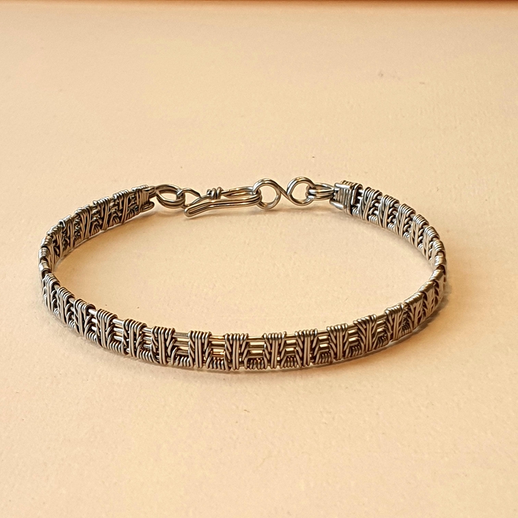 Bracelet tissé en acier inoxydable argenté, fabriqué en France, à Reims, à la main, sans soudure ni colle. Design "épis" . Sans cadmium, sans nickel, sans plomb.