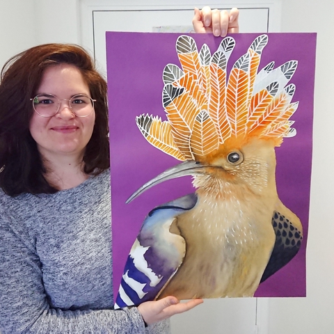 Photo de Elodie Guéguen-Teil avec son oeuvre fétiche, une huppe fasciée. Un magnifique oiseau brun clair avec une grande huppe de plumes sur la tête. 