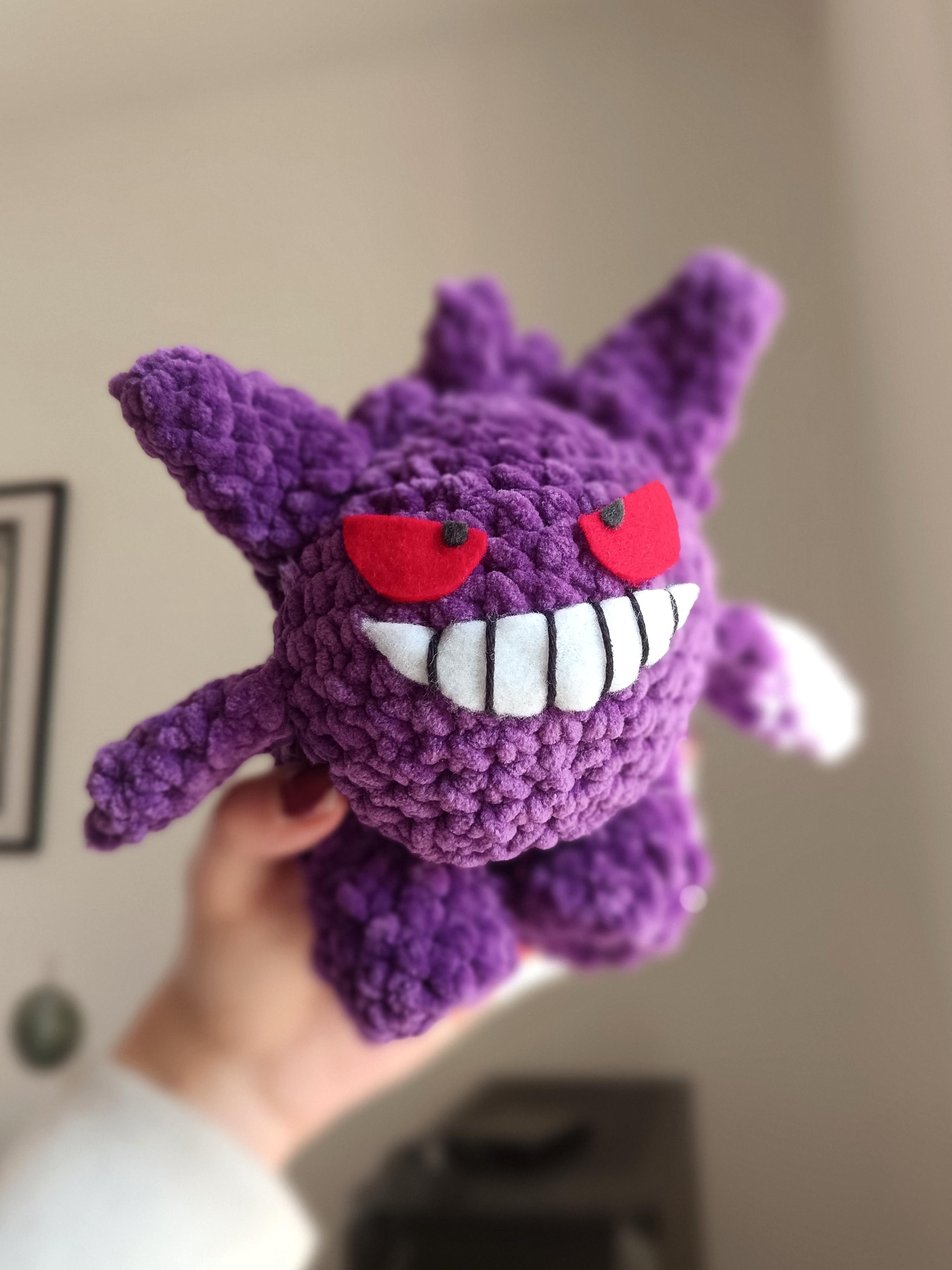 Photo de Mew en crochet, tenu dans une main.