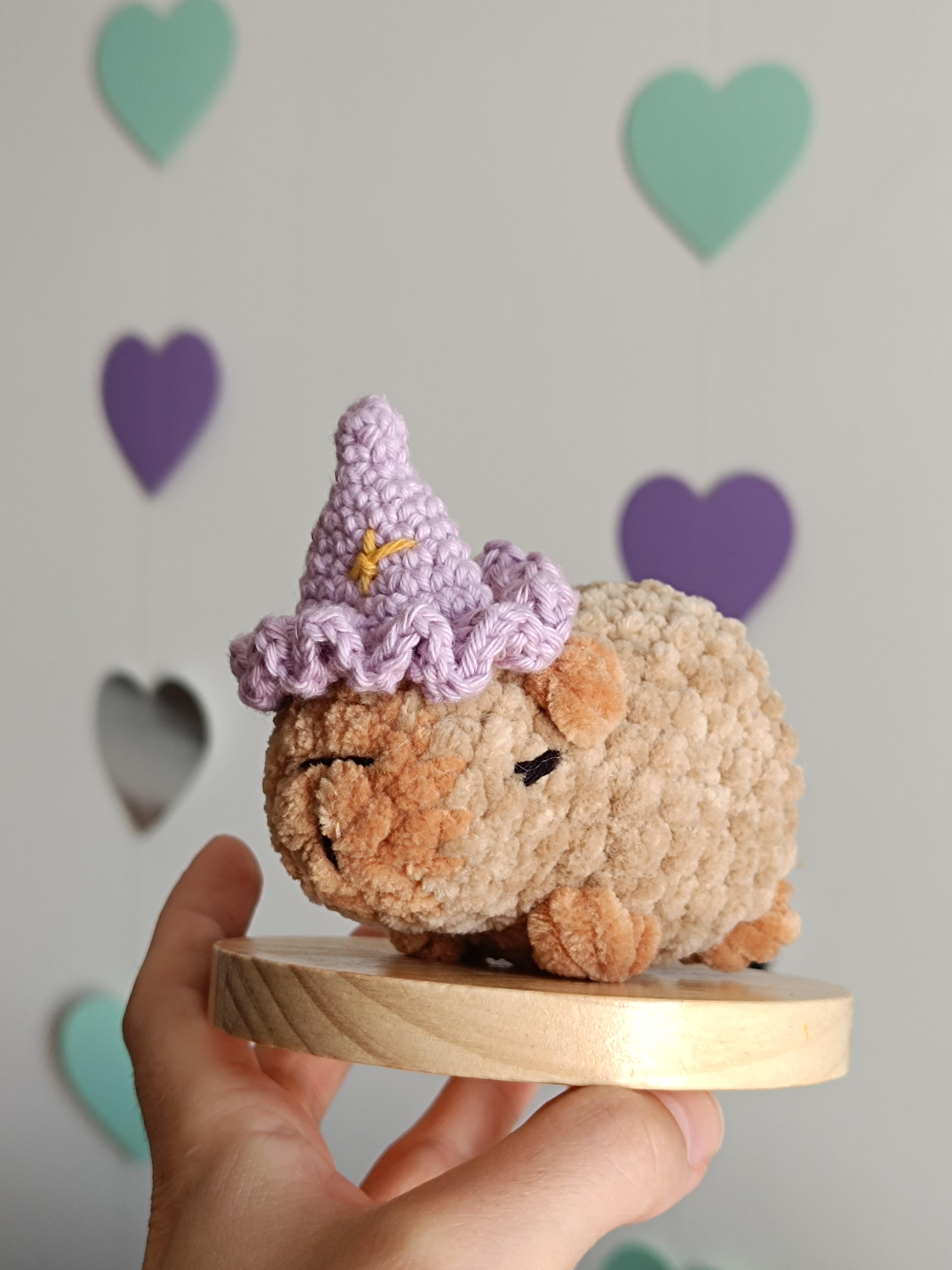 Capybara en crochet avec un petit chapeau de sorcier lilas avec des étoiles jaunes.