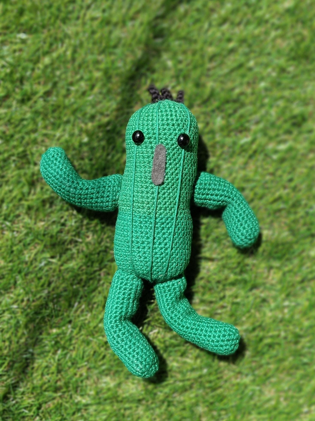 Un pampa de FF14 réalisé en crochet, posé sur du faux gazon.