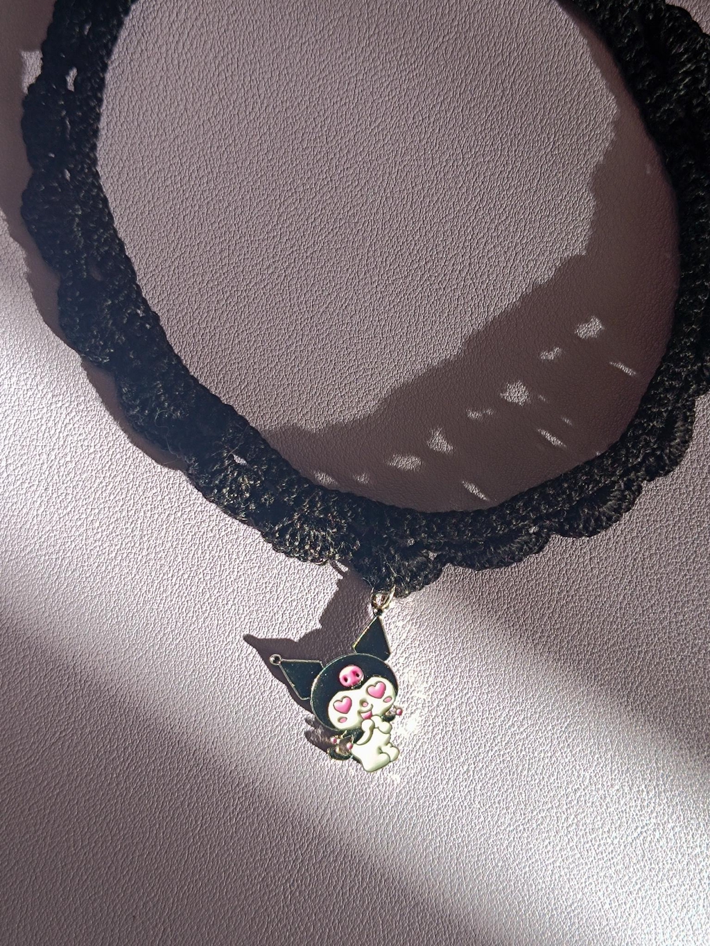un choker en crochet noir avec un pendentif Kuromi