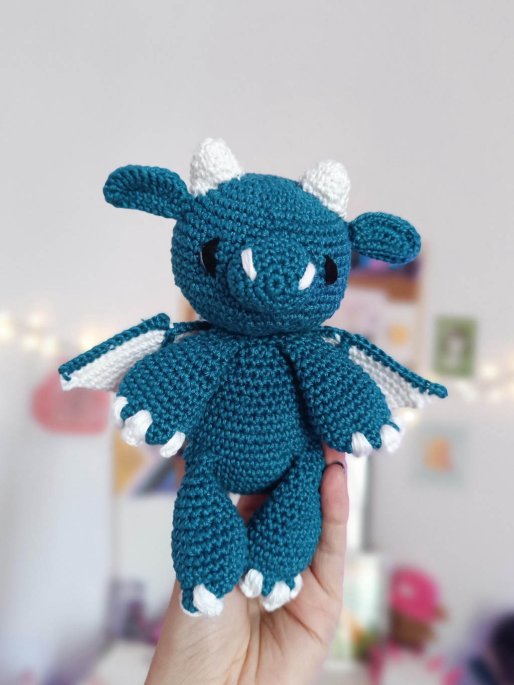 Un dragon en crochet, bleu canard et blanc.