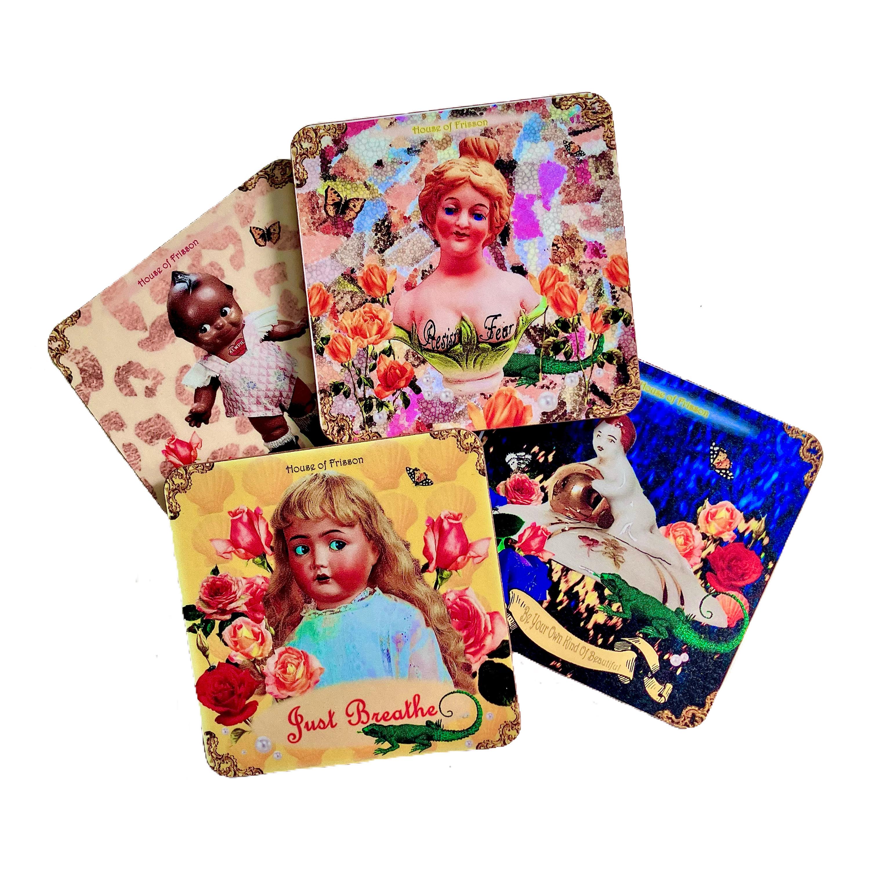 Four square coasters with artistic designs featuring vintage-style illustrations of dolls, flowers, and butterflies. One coaster includes the phrase 'Just Breathe,' and another features 'House of Frisson' along with 'Resist Fear.
