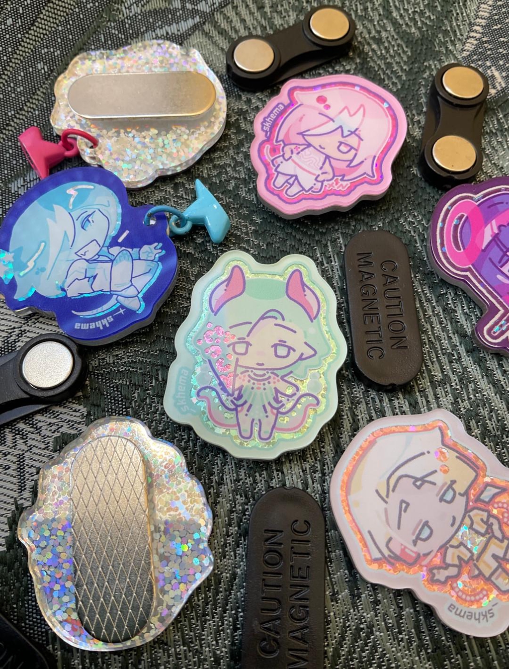 Magnet pins which can be used as fridge magnets too. Most made of acrylic with holographic effects. The designs are depicting my original characters from my self-published BL / yaoi manga comic.