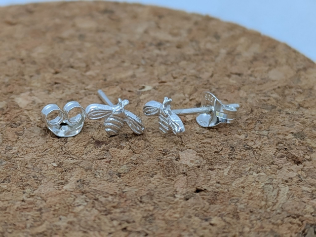 Small hand-crafted sterling silver earrings featuring organic shapes like hearts and butterflies, each with a soft, tactile, and perfectly imperfect finish.